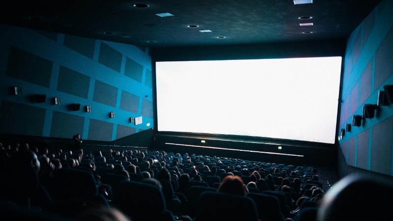A crowded cinema audience seated in a theater watching a movie on a large screen., tags: des regionalen - pexel